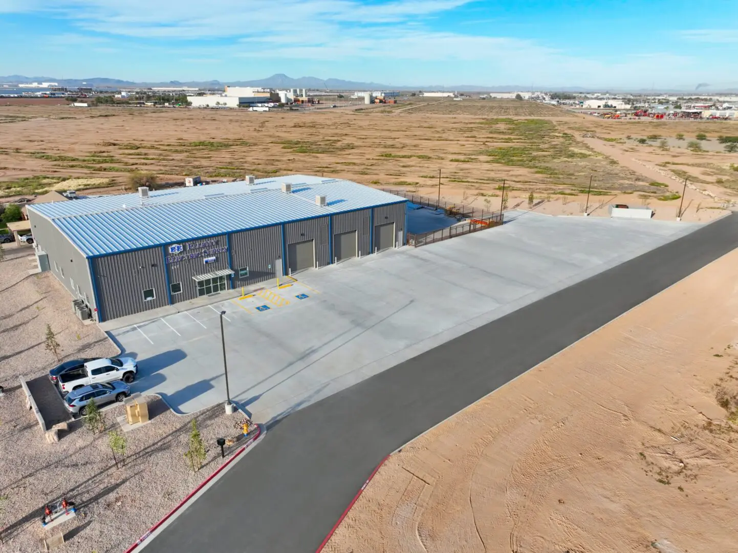 Industrial building with large parking area.
